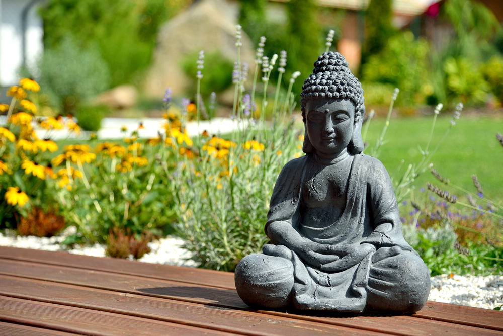 A Peaceful Budda statue infront of a tranquil garden setting