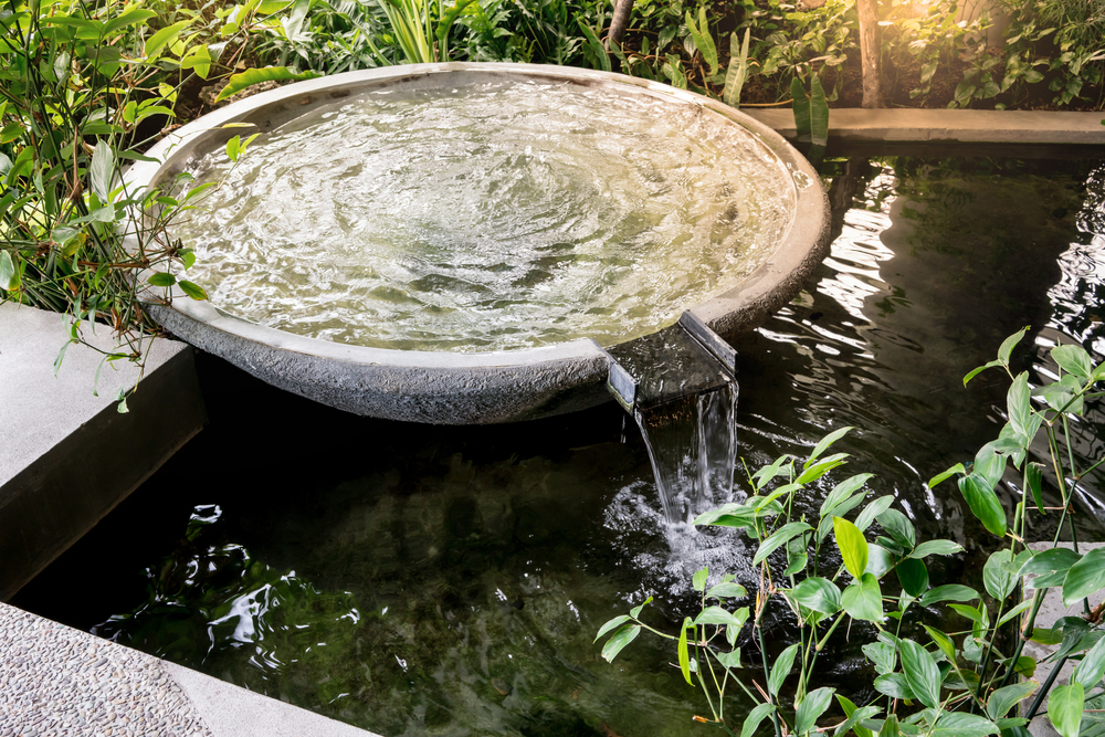 Circle shape water fountain and water fall in garden or park. Landscape design