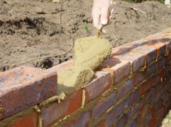 Cement Mortar being laid ob a course of bricks